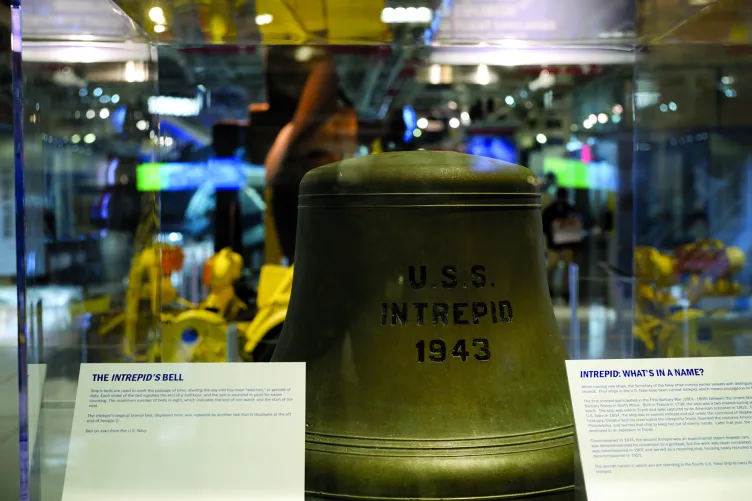 A large brass bell with USS Intrepid imprinted on it