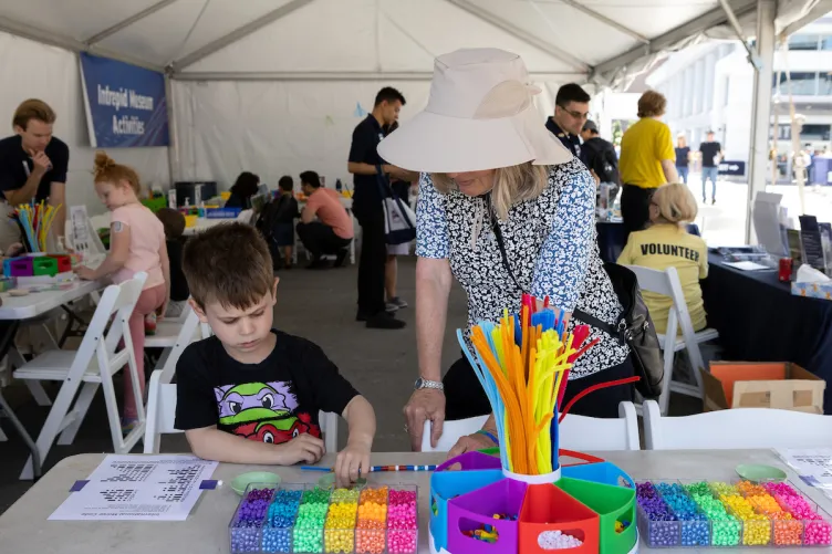 A woman and child engaging in a fun activity on Pier 86 during Fleet Week.