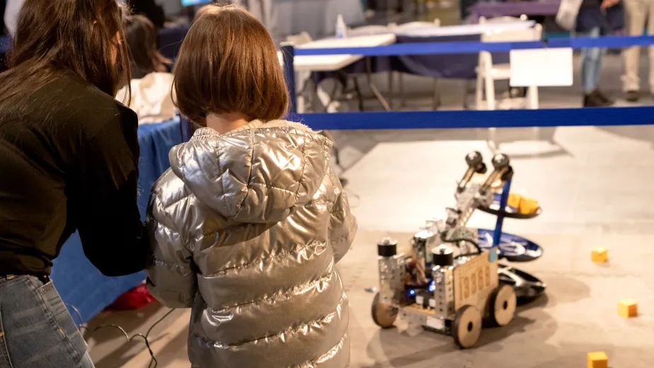 A young girl participating in robotics activities at a museum event