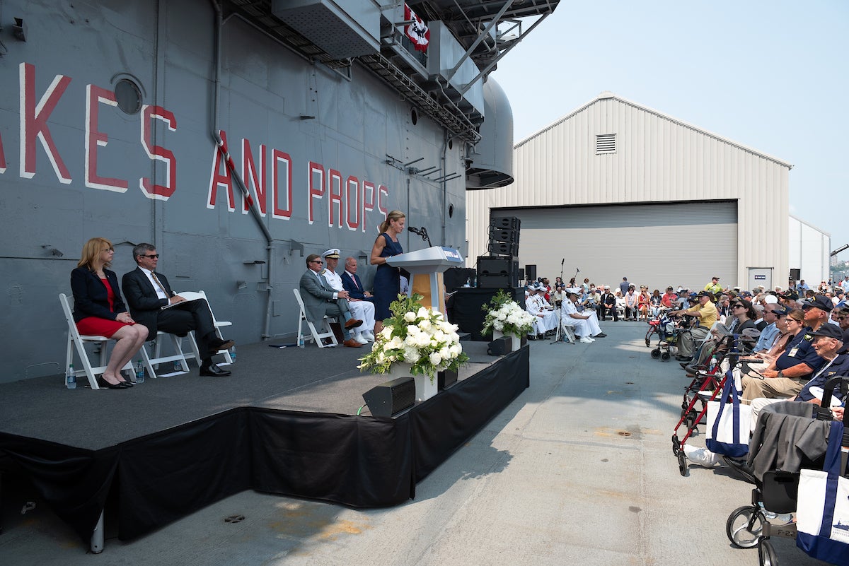 President Susan Marenoff-Zausner speaking to crowd at the 75th Anniversary of the commissioning of the USS Intrepid ceremony. Credit: Intrepid Museum. 