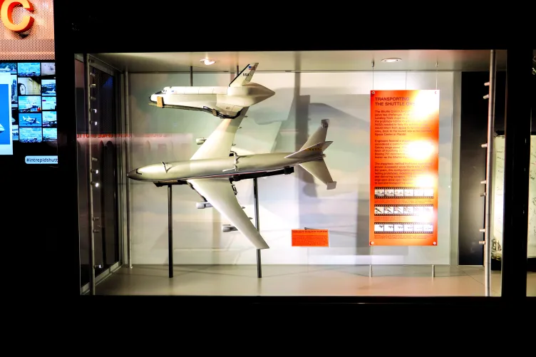 An exhibition case that shows a model of the airplane that carried the Enterprise to it's home at the Intrepid Museum.