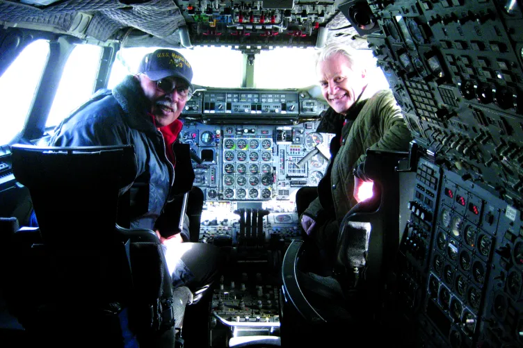 Two people are in the Concorde cockpit, turned around to face the camera behind them.