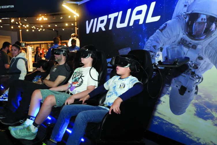 Visitors seated and wearing goggles for the Virtual Reality experience in the Space Shuttle Pavilion.
