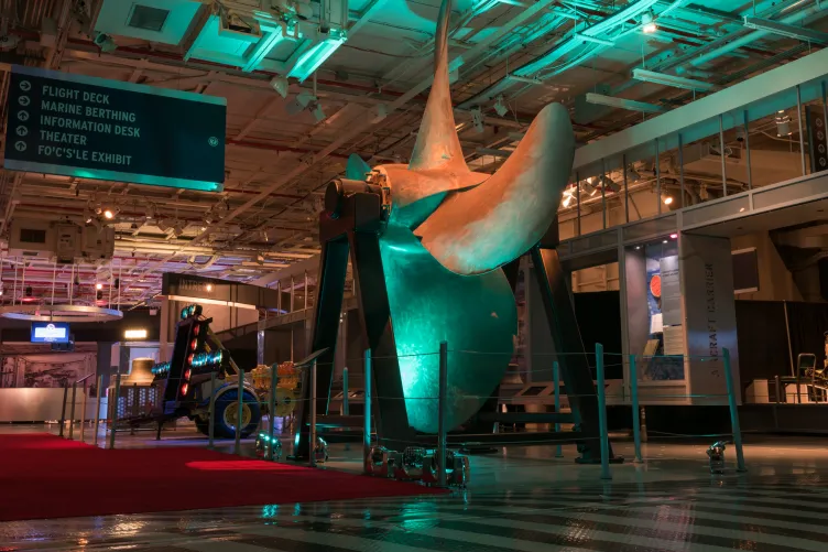 People in rows of seats in front of a stage in hangar 1 for an event