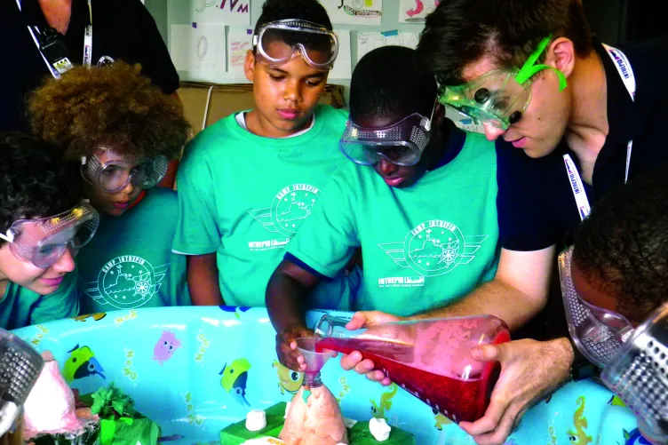 A Museum educator and several children doing an activity.