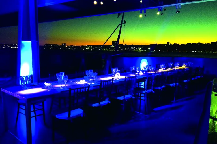 A long table with chairs in the VIP Room extending out into the Fantail