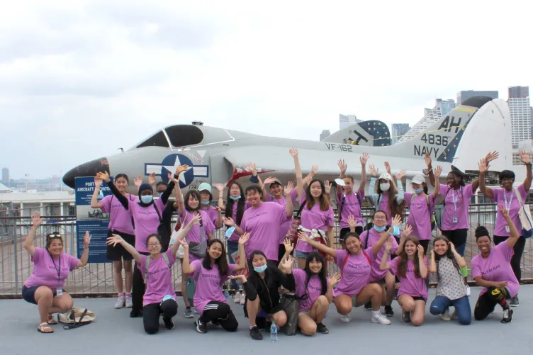 A group of Goals for Girls on the flight deck in front of an airplane