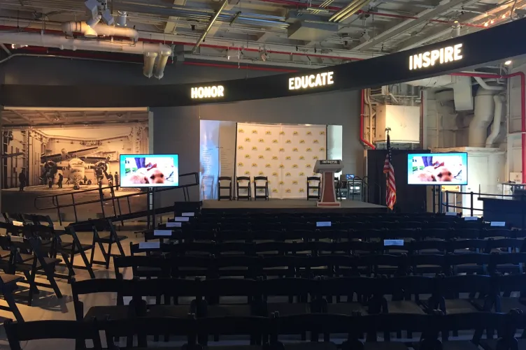 Rows of seats in front of a stage in hangar 1 for an event