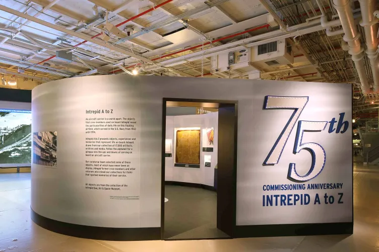 Exhibition walls that read “75th Commissioning Anniversary: Intrepid A to Z”