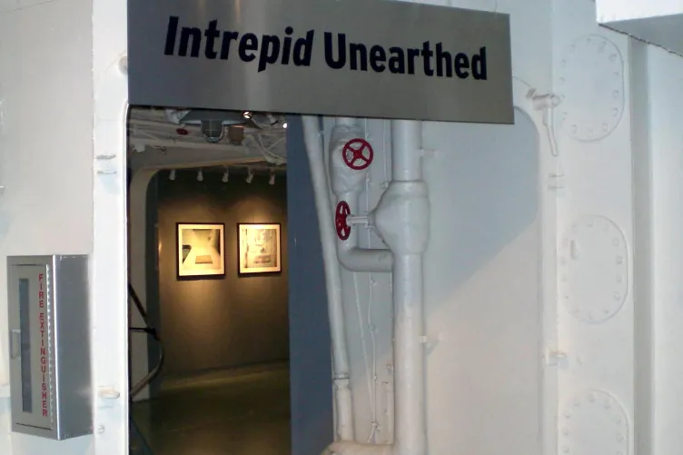 An opening to an exhibition that says “Intrepid Unearthed”