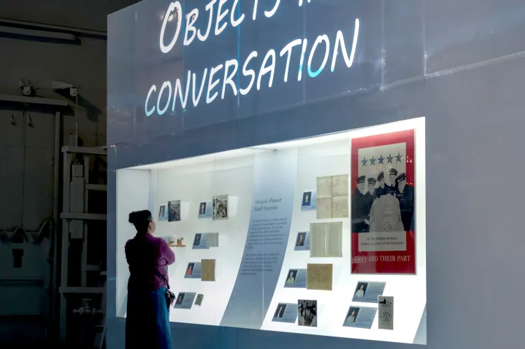 A person is looking at the exhibition panels with feature photos and accompanying documents