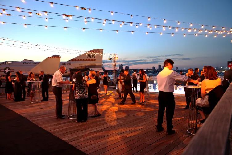 Guests mingling  at an event on the port side aircraft elevator