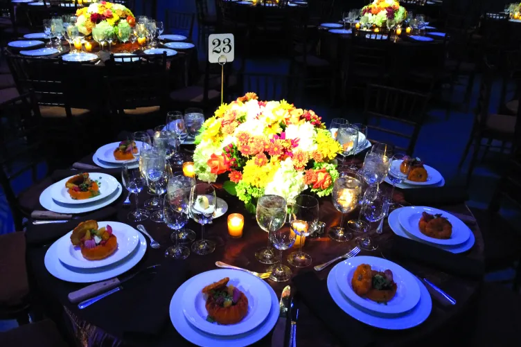 Table setting with large floral centerpiece at a round tables for an event