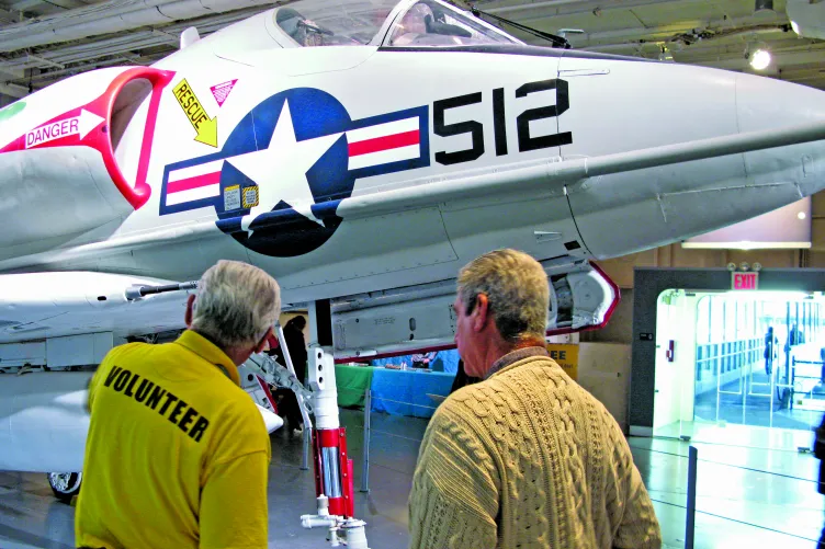 A veteran is speaking with a guest at the Museum.