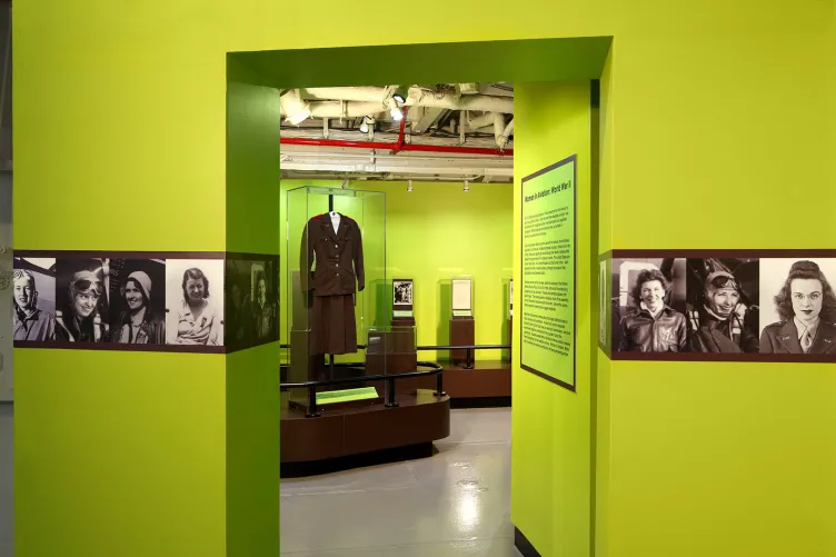 An opening to an exhibition that says “Women in Aviation: World War II” with many photos of women.