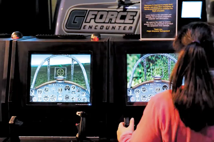 Girl at G-Force Flight Simulator Controls
