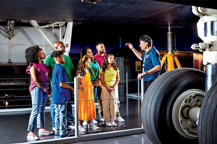 Group visiting at the Enterprise Space Shuttle with a Museum educator