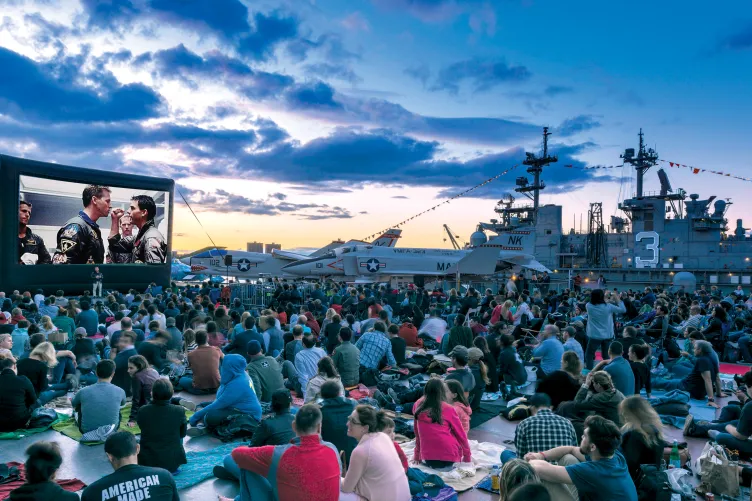 Movie Night Crowd at the Flight Deck during sunset, large movie screen, and Aircraft in the background 