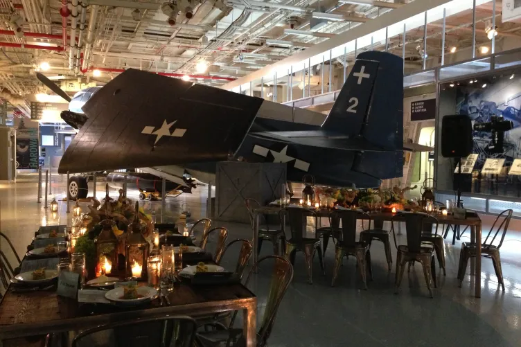 Tables and chairs set up next to the Avenger aircraft at hanger 2