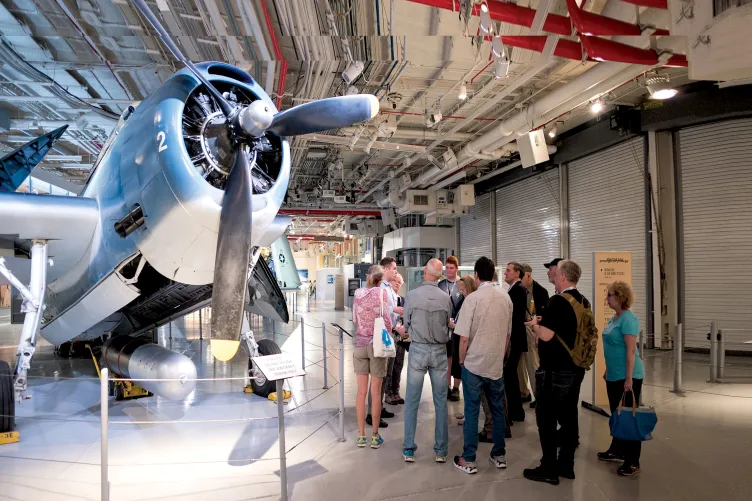 Group of visitors with a museum guide in front of the Avenger