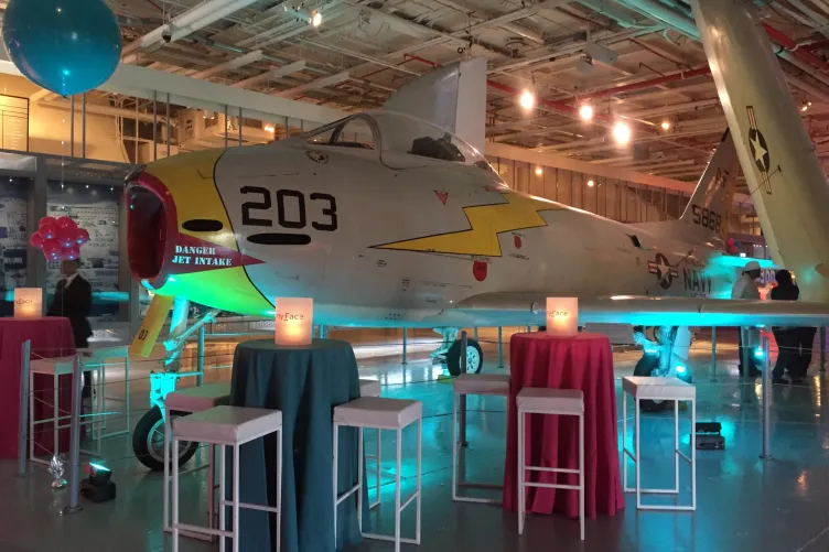 Bar tables and chairs set up next to an aircraft at hanger 2