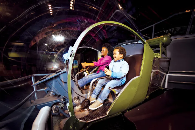 Woman and boy having fun at the Helicopter located at the Exploreum, interactive zone.