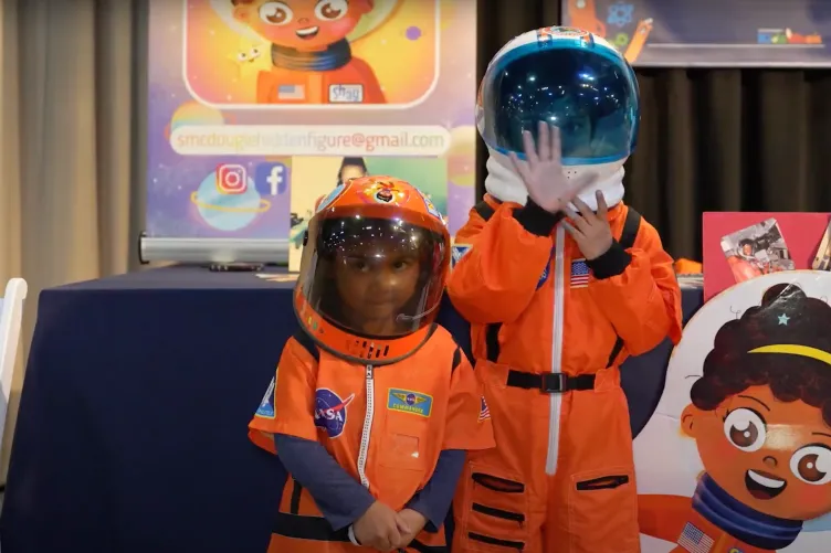 Children wearing astronaut space suits participating in Kids Week activities.