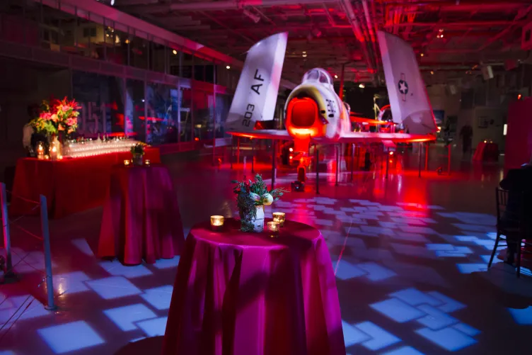 Hangar 2 set for a holiday party with red lighting and decor