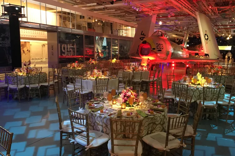 Hangar 2 set for a seated dinner with floral arrangements