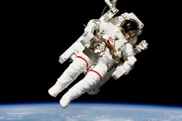 An astronaut floats in space, Earth seen below them.