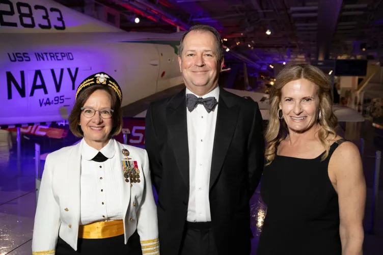 Intrepid executives and honorees posing in front of the Douglas A-4B Skyhawk.