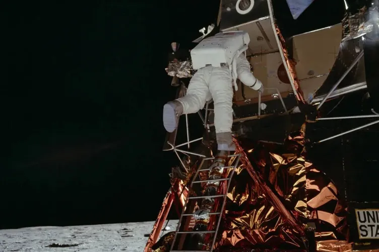 An astronaut descending the ladder of the Apollo 11 Lunar Module.