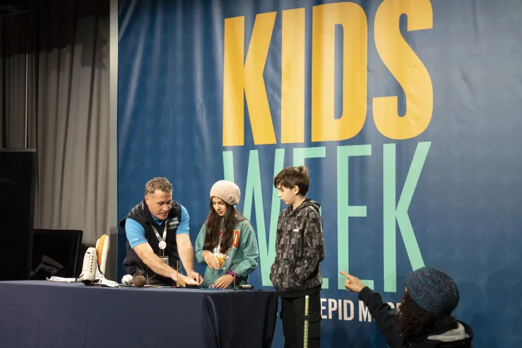 An Intrepid Museum educator presenting to kids in the Exploreum interactive hall during Kids Week