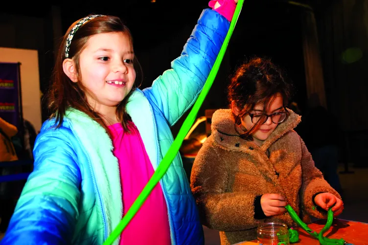 A young girl engaging in an interactive activity during Kids Week.