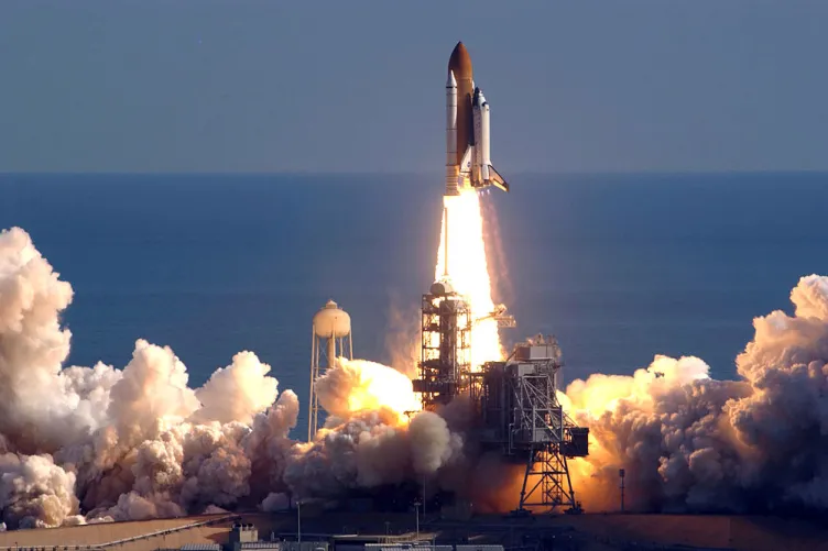 A space shuttle launching into the sky, with a trail of exhaust in the background.