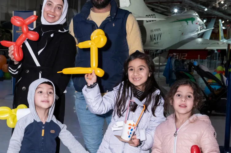 A family learning to make balloon characters together during kids week