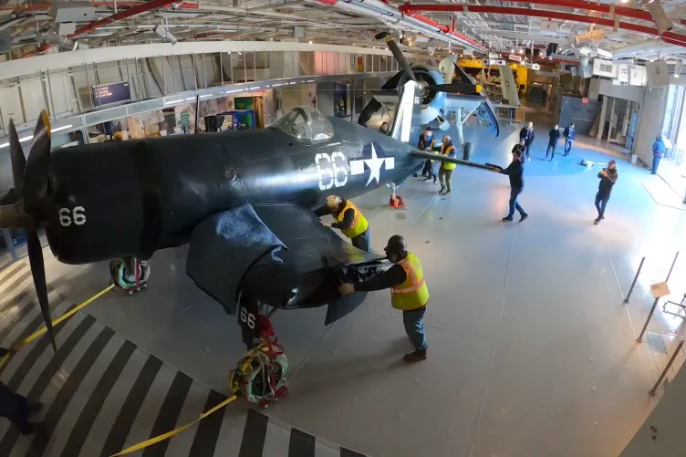 Corsair aircraft inside the Intrepid Museum's hangar deck being moved into its permanent exhibition spot.