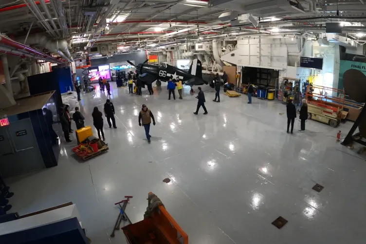 Corsair aircraft inside the Intrepid Museum's hangar deck being moved into its permanent exhibition spot.