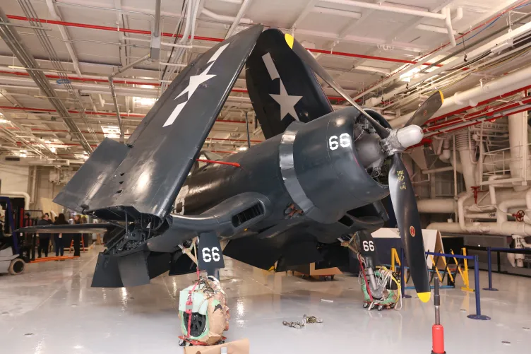 Corsair aircraft inside the Intrepid Museum's hangar deck being moved into its permanent exhibition spot.