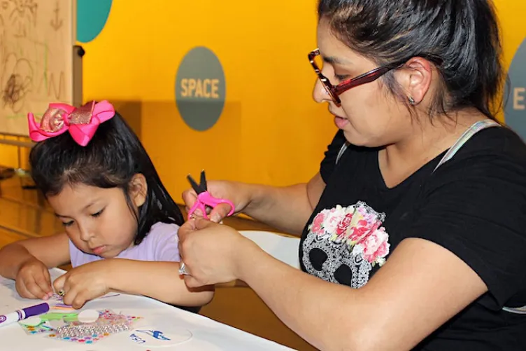 A family participating in a hands-on activity at the Intrepid Museum