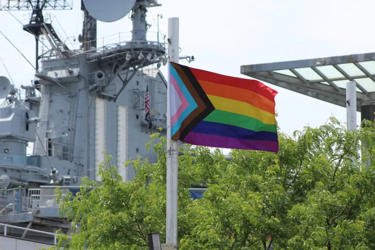 Pride flag waving in front of Pier 86 at the Intrepid Museum