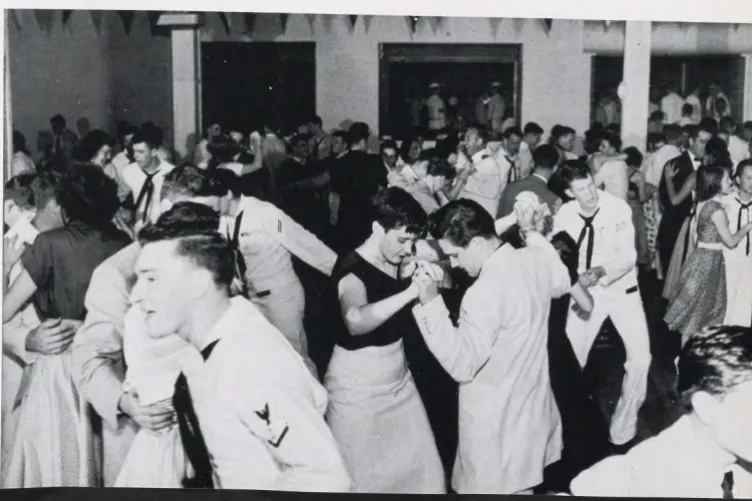 Black and white photo of couples dancing. The men are wearing sailor uniforms.