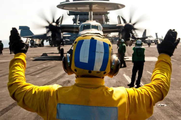 A Landing Signal Officer directing a plane on Intrepid's flight deck.
