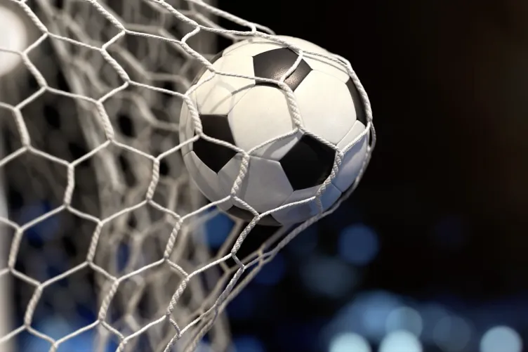 A soccer ball inside the goal net