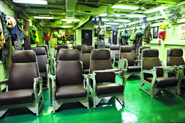 Image of the squadron ready room set up as it looked during active service, with chairs, pilots' suits and helmets.