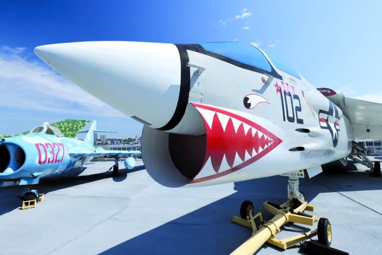 Image of the F-8K Crusader on Intrepid's flight deck, with its nose painted like a shark