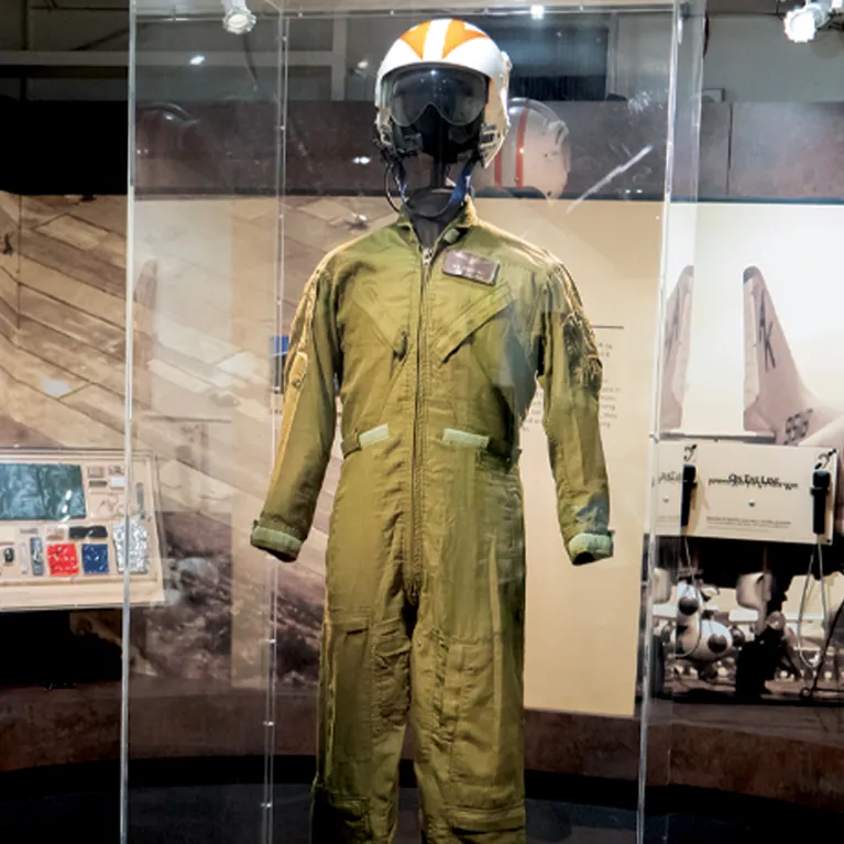 A uniform and helmet is displayed in an exhibition case.