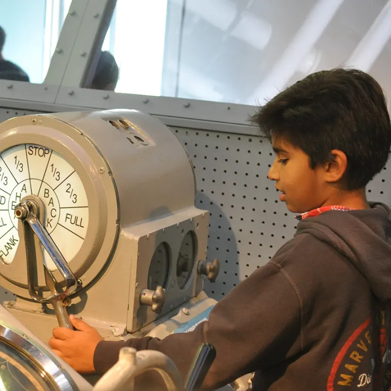 A child is playing with a radar simulation in the Exploreum.