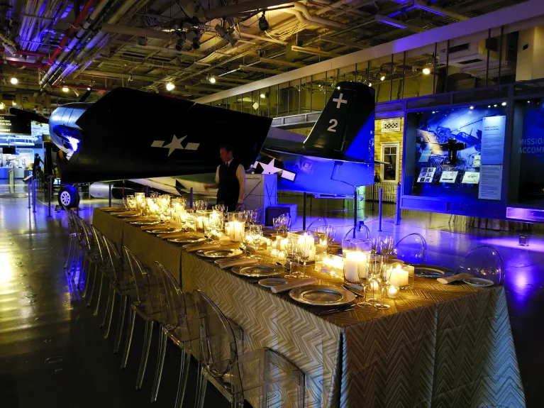 One long table and chairs set up for an event on the hangar deck