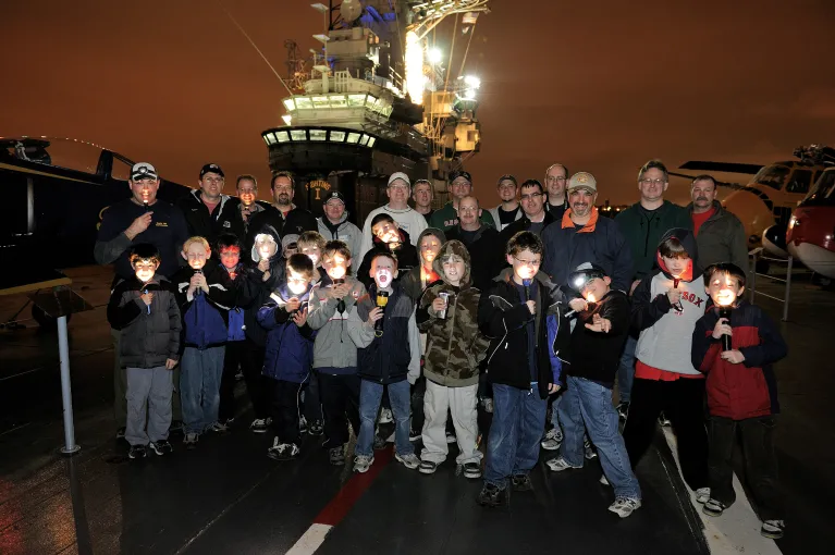 Kids and their parents with flashlights on the flight deck